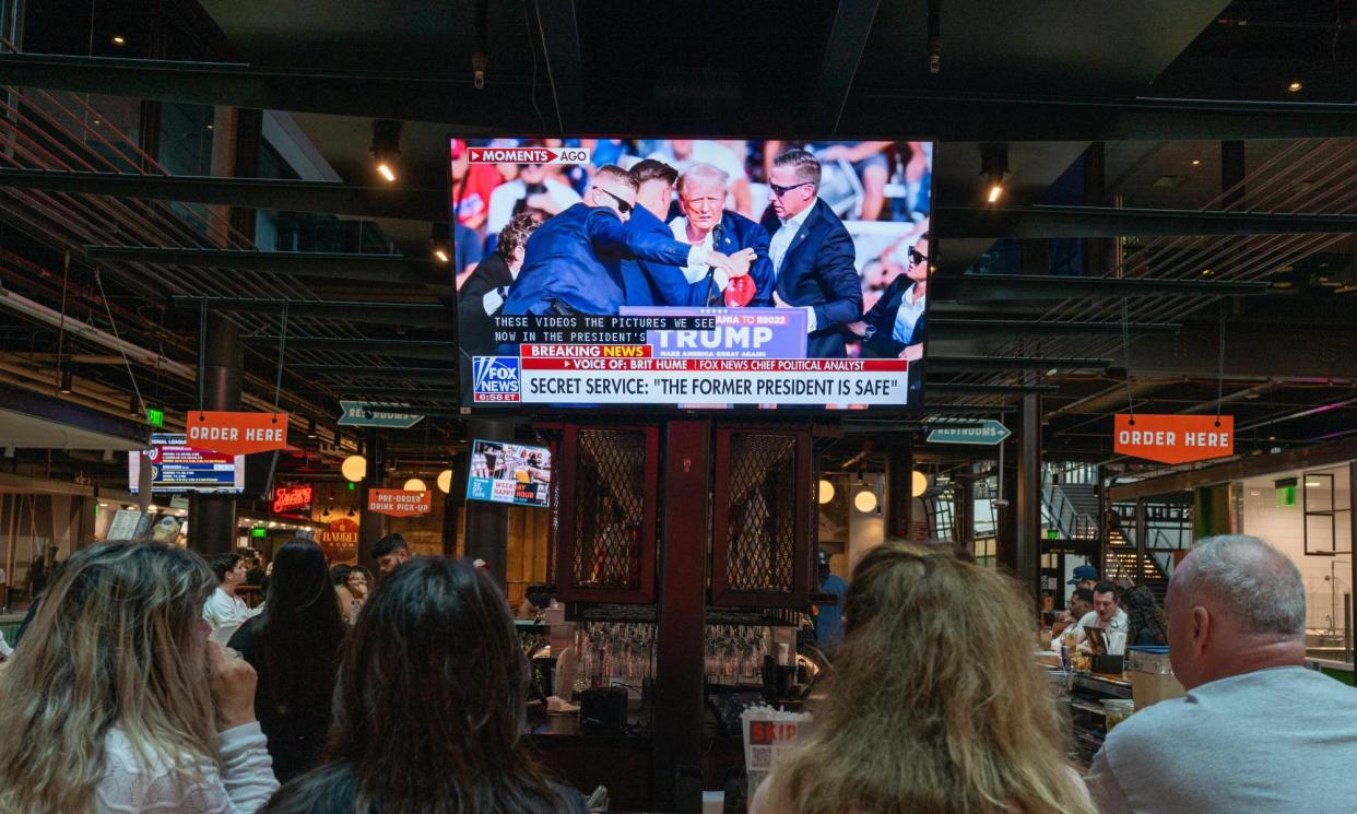 <span>People watch the news of the attempted assassination on Donald Trump at a bar in Milwaukee, on Saturday.</span><span>Photograph: Spencer Platt/Getty Images</span>