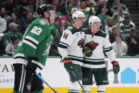 Minnesota Wild's Joel Eriksson Ek (14) and Kirill Kaprizov, right, celebrate a goal by Eriksson Ek, as Dallas Stars defenseman Esa Lindell (23) skates past during the second period of an NHL hockey game Wednesday, Feb. 8, 2023, in Dallas. (AP Photo/Tony Gutierrez)