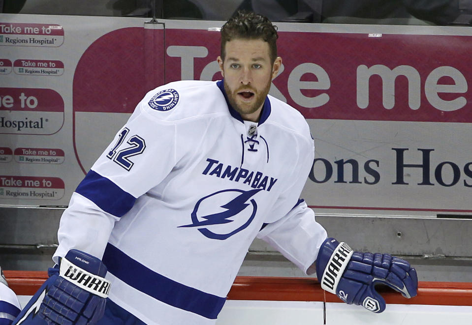 This Feb. 4, 2014 photo, Tampa Bay Lightning left wing Ryan Malone (12) stretches before an NHL hockey game against the Minnesota Wild in St. Paul, Minn. Malone was charged Saturday with DUI and possession of cocaine after a traffic stop, police said. An officer saw Malone's SUV strike a curb after making a left turn from the center lane early Saturday, said Tampa Police Lt. Paul Lusczynski. After being pulled over, Malone got out of his vehicle, and the officer smelled alcohol on his breath, Lusczynski said. According to the police report, the officer also found 1.3 grams of cocaine in one of Malone's pockets. Malone was released from the Hillsborough County jail on $2,500 bond. (AP Photo/Ann Heisenfelt)