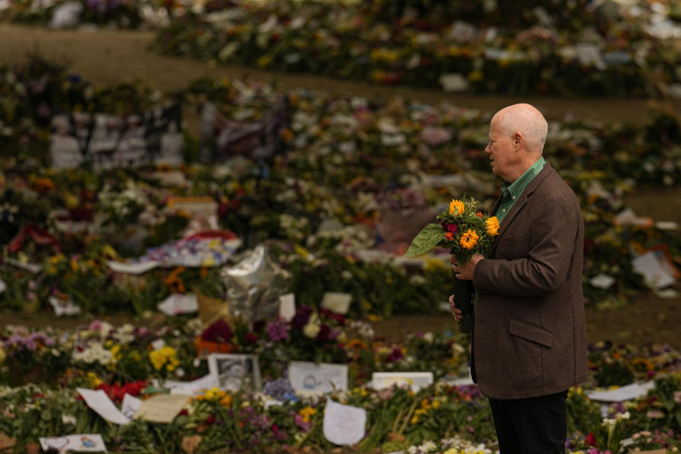 People bring floral tributes to Queen Elizabeth II, the day after her funeral in London's Green Park, Tuesday, Sept. 20, 2022. The Queen, who died aged 96 on Sept. 8, was buried at Windsor alongside her late husband, Prince Philip, who died last year. (AP Photo/Vadim Ghirda)