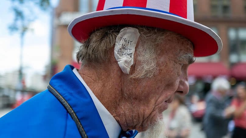 Seguidor de Trump en Milwaukee con una venda en la oreja con la frase "lucha, lucha, lucha"