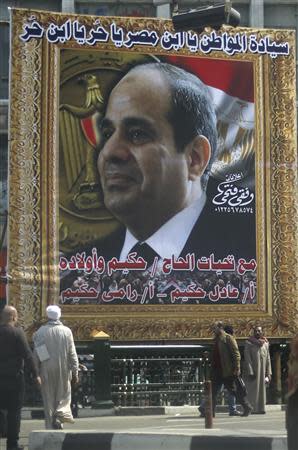 People walk past a banner for Egypt's army chief, Field Marshal Abdel Fattah al-Sisi, in downtown Cairo, March 24, 2014. REUTERS/Amr Abdallah Dalsh