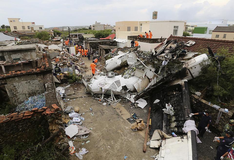 Rescue personnel survey the wreckage of a TransAsia Airways turboprop plane that crashed, on Taiwan's offshore island Penghu July 24, 2014. The leaders of rivals China and Taiwan expressed condolences on Thursday for victims of the plane that crashed during a thunderstorm the previous day killing 48 people including two French nationals. (REUTERS/Stringer)