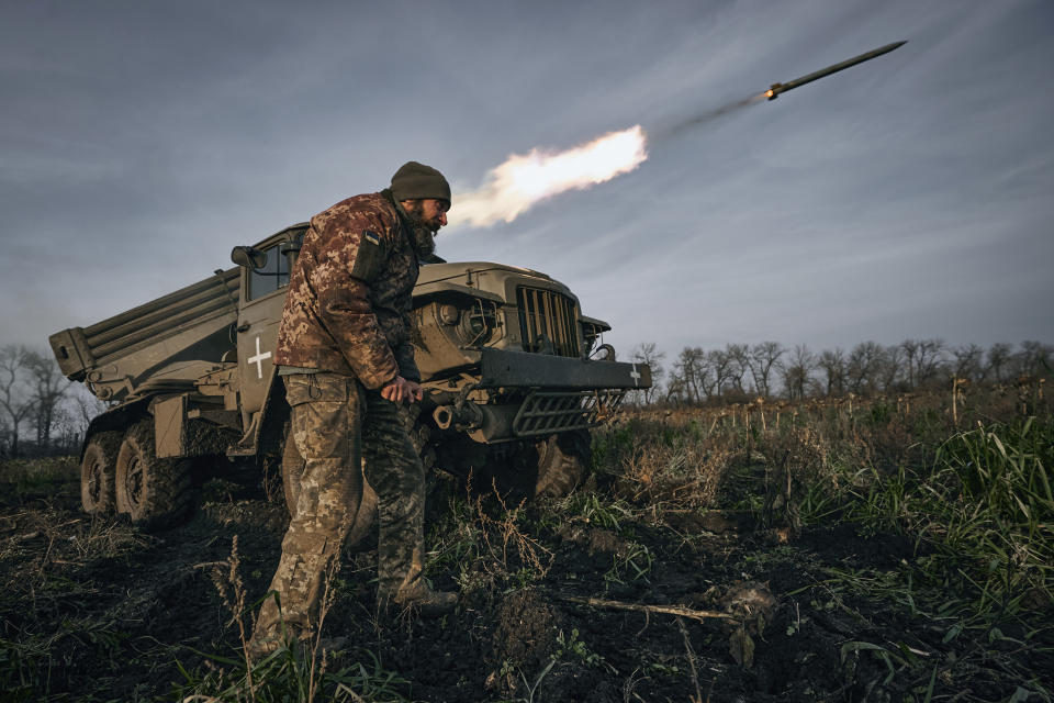 FILE - Ukrainian military's Grad multiple rocket launcher fires rockets at Russian positions in the frontline near Bakhmut, Donetsk region, Ukraine, Thursday, Nov. 24, 2022. War has been a catastrophe for Ukraine and a crisis for the globe. One year on, thousands of civilians are dead, and countless buildings have been destroyed. Hundreds of thousands of troops have been killed or wounded on each side. Beyond Ukraine’s borders, the invasion shattered European security, redrew nations’ relations with one another and frayed a tightly woven global economy. (AP Photo/LIBKOS, File)