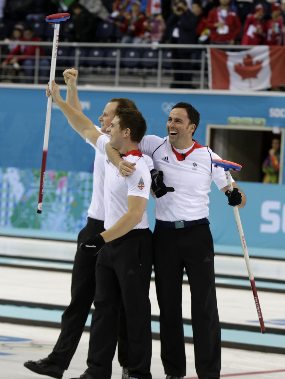 Britain’s skip David Murdoch, right, celebrates with teammates Michael Goodfellow, left, and Greg Drummond after defeating Sweden during the men's curling semifinal game at the 2014 Winter Olympics, Wednesday, Feb. 19, 2014, in Sochi, Russia. (AP Photo/Robert F. Bukaty)