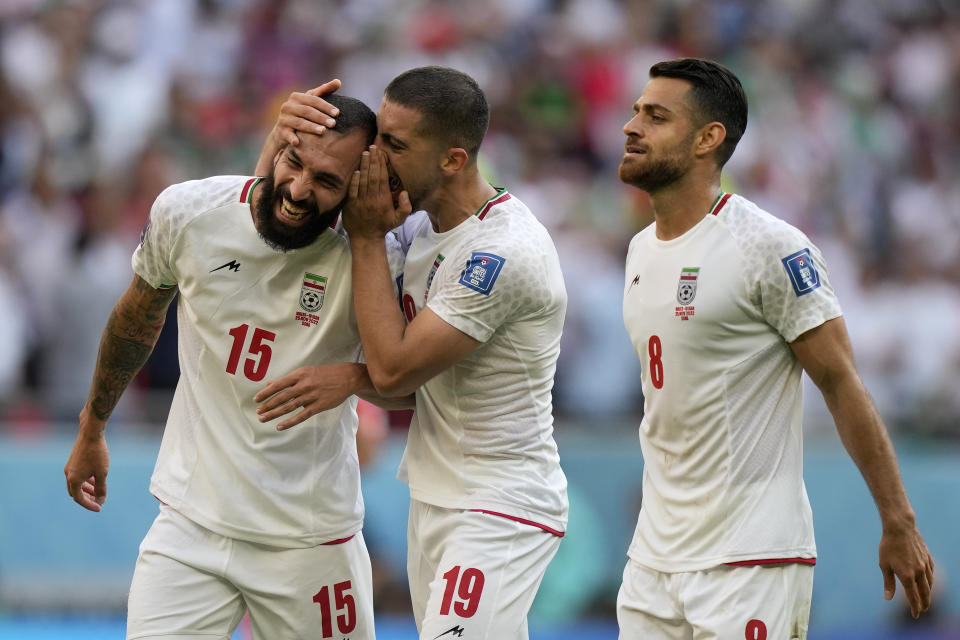 Iran's Majid Hosseini, from right, Iran's Morteza Pouraliganji and Iran's scorer Rouzbeh Cheshmihe celebrate after winning the World Cup group B soccer match between Wales and Iran, at the Ahmad Bin Ali Stadium in Al Rayyan , Qatar, Friday, Nov. 25, 2022. (AP Photo/Frank Augstein)