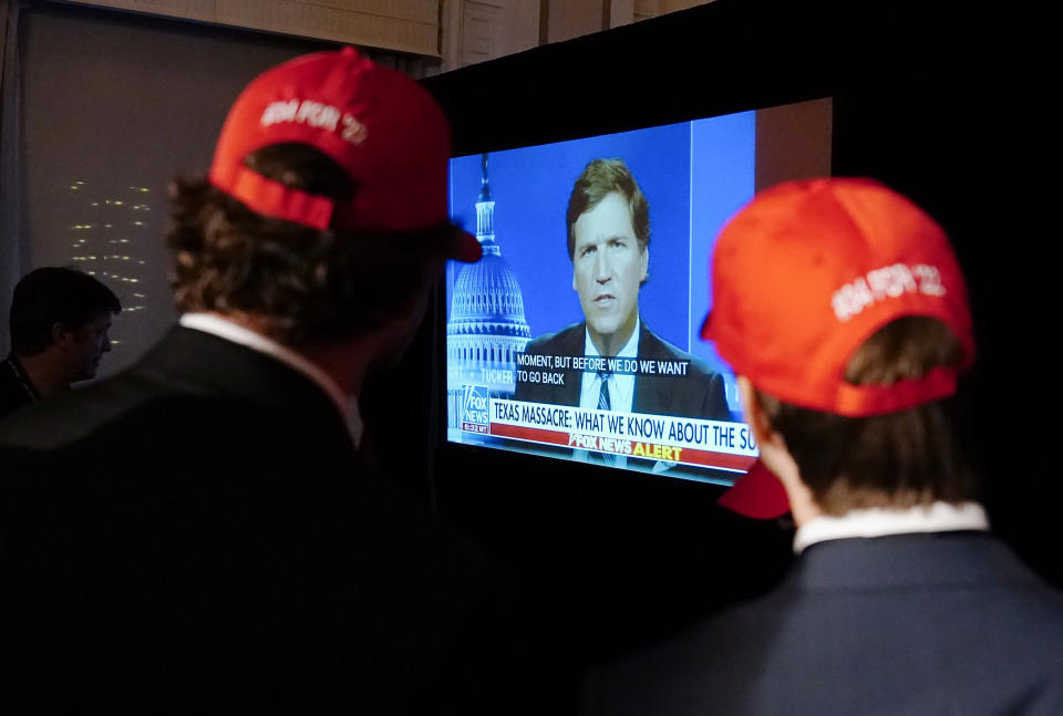 FILE - Supporters wait to hear U.S. Senate candidate Herschel Walker speak during an election night watch party as they watch TV host Tucker Carlson, May 24, 2022, in Atlanta. Fox News says it has agreed to part ways with Tucker Carlson, less than a week after settling a lawsuit over the network’s 2020 election reporting. (AP Photo/Brynn Anderson, File)