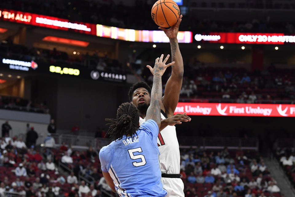 Louisville forward Sydney Curry (21) attempts a shot over North Carolina forward Armando Bacot (5) during the second half of an NCAA college basketball game in Louisville, Ky., Saturday, Jan. 14, 2023. North Carolina won 59-80. (AP Photo/Timothy D. Easley)