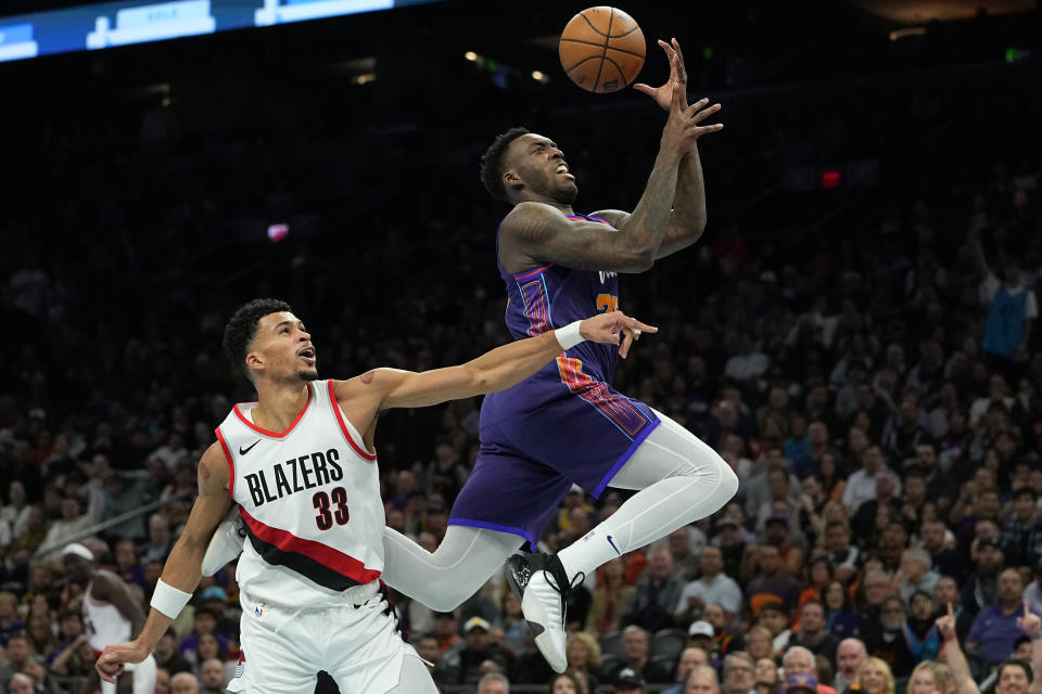 Phoenix Suns forward Nassir Little is fouled by Portland Trail Blazers forward Toumani Camara (33) during the second half of an NBA In-Season Tournament basketball game, Tuesday, Nov. 21, 2023, in Phoenix. (AP Photo/Matt York)