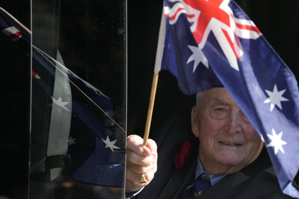 A veteran waves and Australian flag during the Anzac Day parade in Sydney, Tuesday, April 25, 2023. (AP Photo/Rick Rycroft)