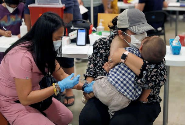 PHOTO: FILE - Namrata Nayyar, left center, kisses her son Ari Dawra, 18 months, as he receives his Covid-19 vaccination from licensed vocational nurse Jacqueline Cinco at the Santa Clara County Fairgrounds in San Jose, Calif., June 21, 2022. (Medianews Group/the Mercury News/MediaNews Group via Getty Images, FILE)