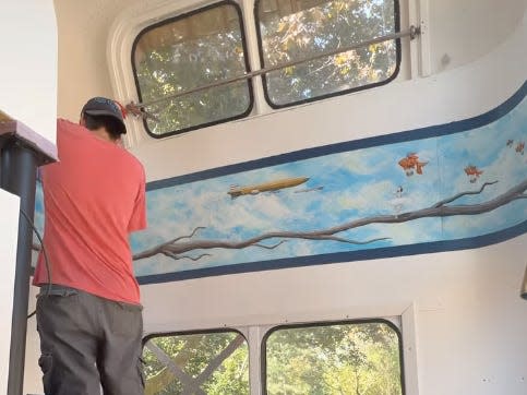 Scott preserving the painting in the bus that came from its Grilled Cheese Grill days.