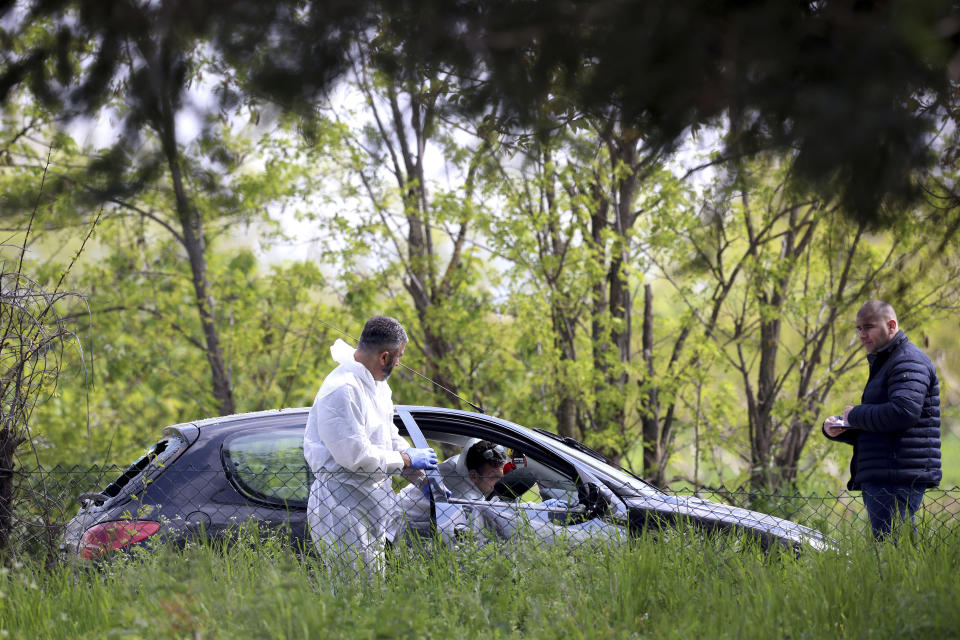 Forensic police operate on a car in the village of Dubona, some 50 kilometers (30 miles) south of Belgrade, Serbia, Friday, May 5, 2023. A shooter killed multiple people and wounded more in a drive-by attack late Thursday in Serbia's second such mass killing in two days, state television reported. (AP Photo/Armin Durgut)