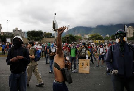 A demonstrator uses a slingshot while gathering in front of a Venezuelan Air Force base during a rally against Venezuelan President Nicolas Maduro's government in Caracas, Venezuela, June 24, 2017. REUTERS/Ivan Alvarado