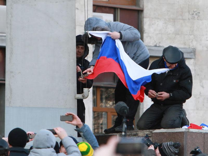 In Donezk, der Heimat des gestürzten Präsidenten Viktor Janukowitsch, hissen pro-russische Demonstranten die russische Flagge. Foto: Photomig