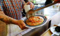 A man in need receives vegetable soup in a plastic cup to take away from the soup kitchen "Kana" in a poor district of the city of Dortmund, western Germany, April 7, 2017. REUTERS/Wolfgang Rattay