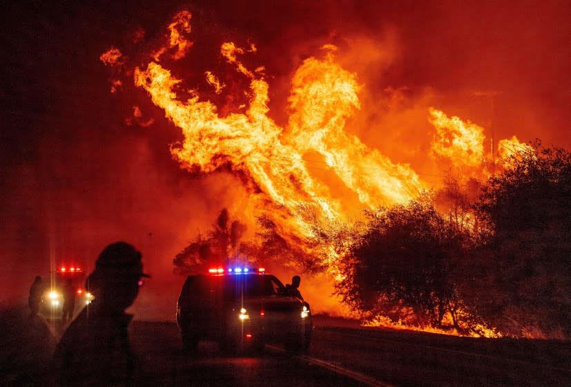 TOPSHOT - A law enforcement officer watches flames launch into the air as fire continues to spread at the Bear fire in Oroville, California on September 9, 2020. - Dangerous dry winds whipped up California's record-breaking wildfires and ignited new blazes, as hundreds were evacuated by helicopter and tens of thousands were plunged into darkness by power outages across the western United States. (Photo by JOSH EDELSON / AFP) (Photo by JOSH EDELSON/AFP via Getty Images)