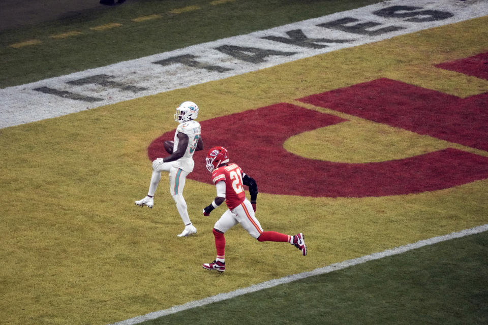 Miami Dolphins running back Raheem Mostert, left, scores on a 13-yard run past Kansas City Chiefs safety Mike Edwards (21) during the second half of an NFL football game Sunday, Nov. 5, 2023, in Frankfurt, Germany. (AP Photo/Markus Schreiber)