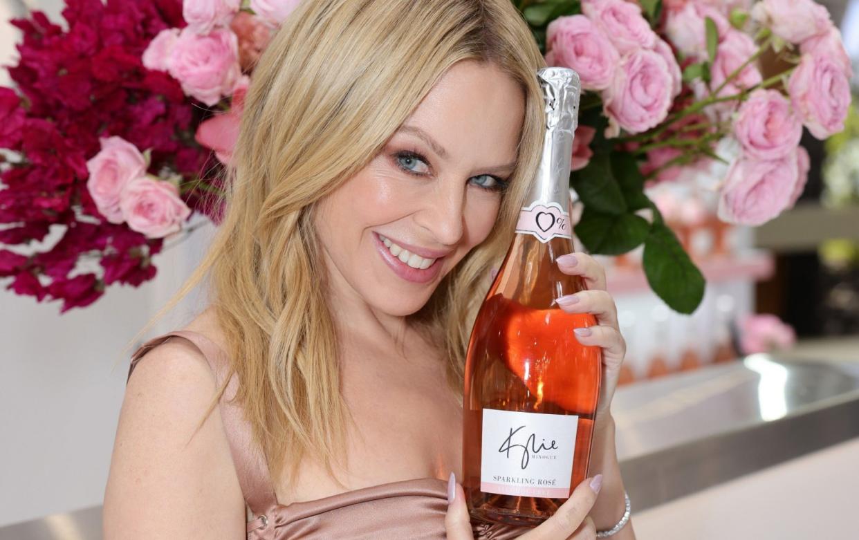 Kylie Minogue holding a bottle of her alcohol-free sparkling rosé