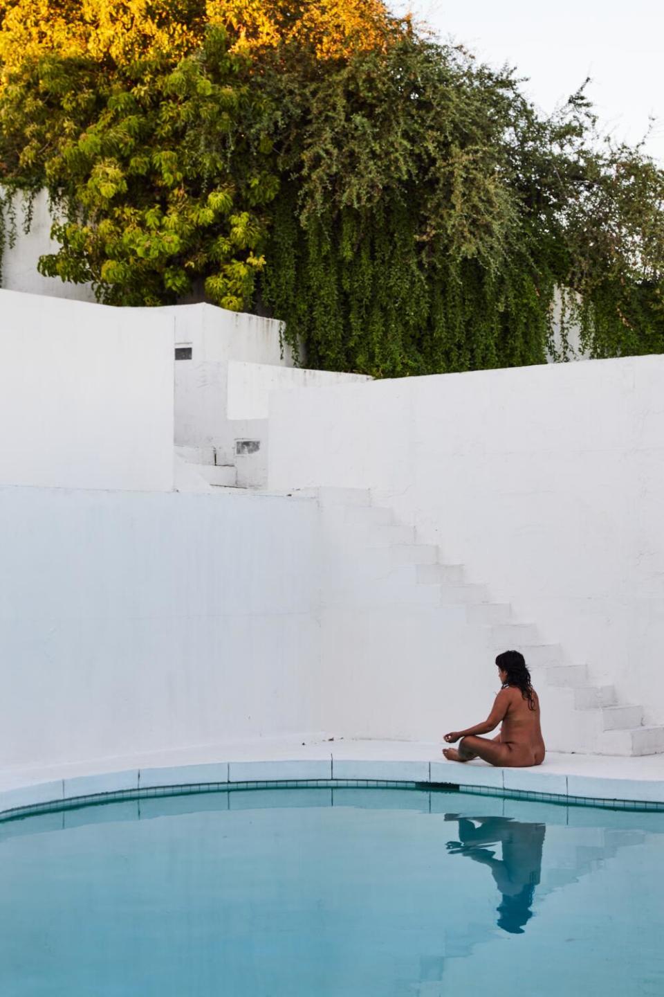 A guest is reflected by the Caster House pool while doing breathwork.
