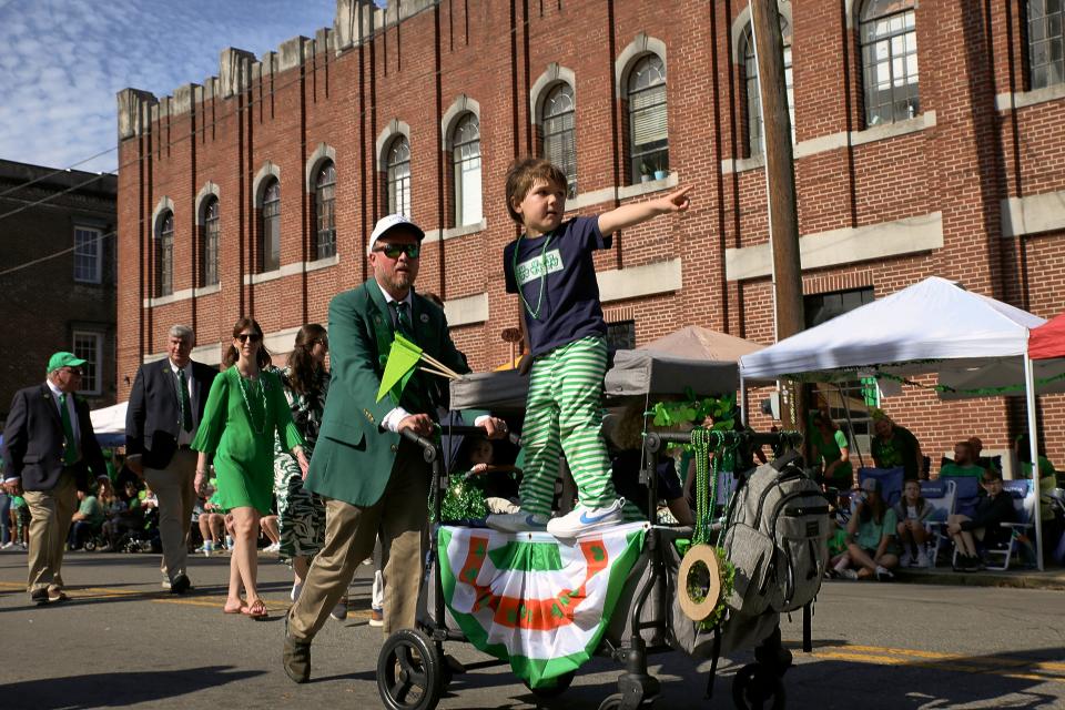 A child points the way as he rides on a wagon during the Savannah St. Patrick's Day Parade on Saturday, March 16, 2024.