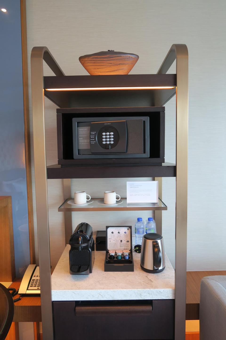 保險箱、咖啡機與杯具整齊收納在同一個架子上。
