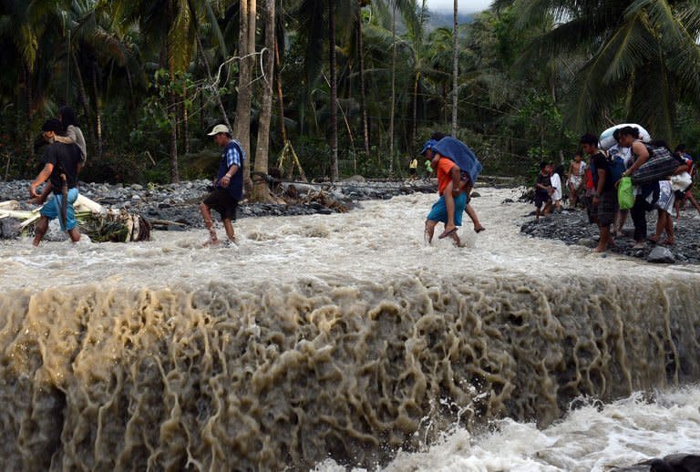 Residents cross a road destroyed by Typhoon Bopha in the village of Andap, New Bataan town on December 5. Manila has appealed for international assistance after a deadly typhoon killed 477 people left a quarter of a million homeless