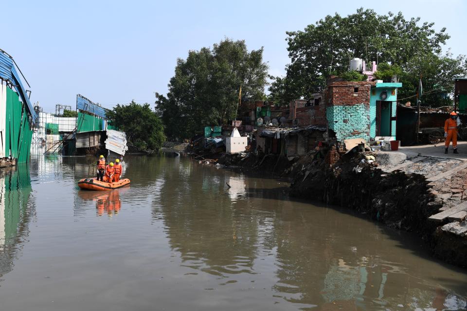 National Disaster Response Force personnel inspect on a dinghy the area where some shanty houses collapsed into a canal due to heavy rains in New Delhi on July 19, 2020. (Photo by Sajjad HUSSAIN / AFP) (Photo by SAJJAD HUSSAIN/AFP via Getty Images)