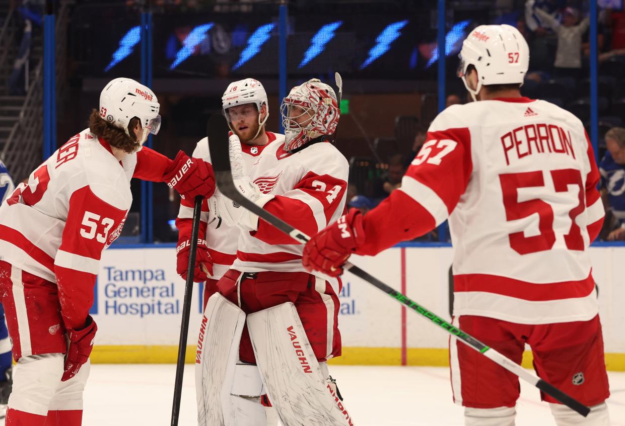 Detroit Red Wings goaltender Alex Lyon celebrates with defenseman Moritz Seider and left wing David Perron after they beat the Tampa Bay Lightning at Amalie Arena in Tampa, Florida on April 1, 2024.