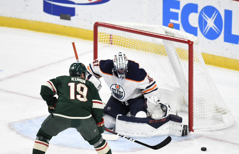 Edmonton Oilers goalie Mike Smith, right, stops the shot of Minnesota Wild's Luke Kunin in the first period of an NHL hockey game, Thursday, Dec.12, 2019, in St. Paul, Minn. (AP Photo/Tom Olmscheid)