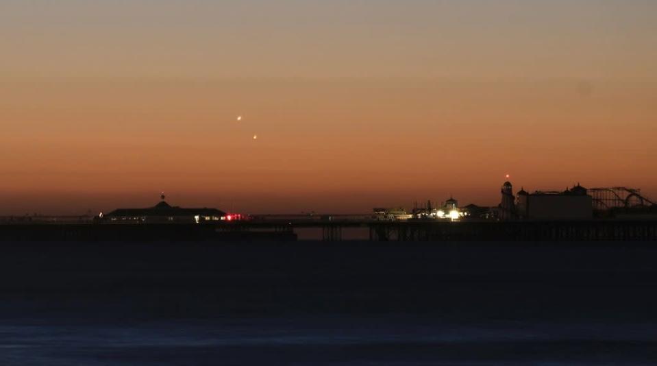 Handout photo of Venus (left) and Jupiter in the skies over Brighton Pier during a planetary conjunction (PA) (PA Media)