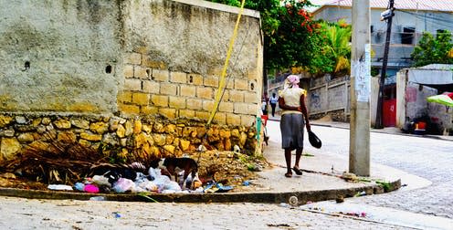   <span class="attribution"><span class="source">A woman walks along a street in Port-au-Prince's wealthiest district, Petionville. © Fiona de Hoog</span>, <span class="license">Author provided</span></span>