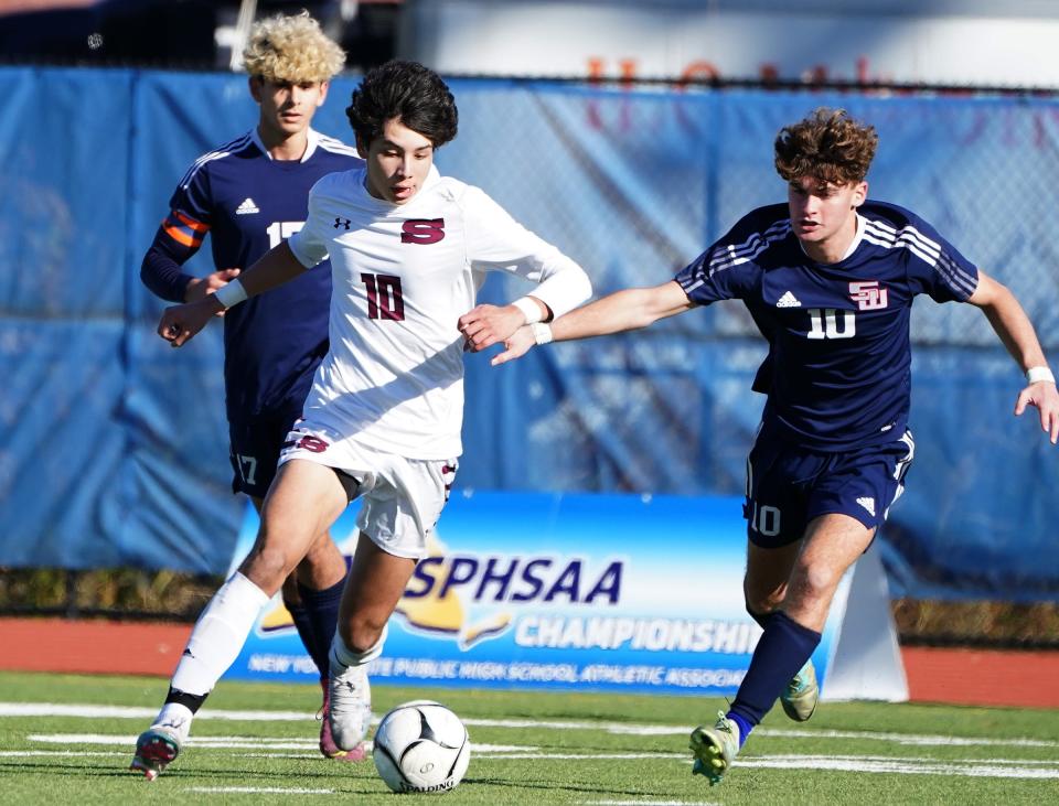 ScarsdaleÕs Lorenzo Galeano (10) works against Smithrown WestÕs Peyton McGrade (10) during their 4-1 win over Smithtown West in the NYSPHSAA boys soccer Class AA semifinal at Middletown High School in Middletown on Saturday, November 2023.