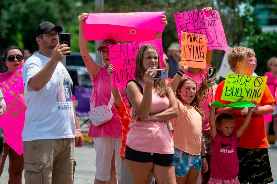 Protestors in support of Heather Wyatt and Aubreigh Wyatt hold signs, take photos and livestream on various social media platforms outside the Jackson County Courts building on Thursday, July 18, 2024, as Heather Wyatt participates in a chancery court hearing inside the courthouse.