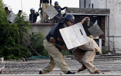 A Pakistani policeman detains a demonstrator during a protest against the US-made film "Innocence of Muslims" in Lahore. Ties between Pakistan and the US are improving after hitting a low point, Pakistani Foreign Minister Hina Rabbani Khar insisted Friday, even as violent anti-US protests rocked her country