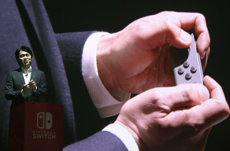 Nintendo Switch General Producer Yoshiaki Koizumi shows how the Joy-Con controller works at the launch event in Japan