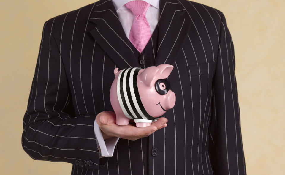 Banker holding a burglar piggy bank.