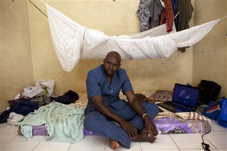 Adama Cisse, 34, a businessman from Gao displaced by the war there two years ago, poses for a picture on his bed at his home in Bamako February 27, 2014. REUTERS/Joe Penney