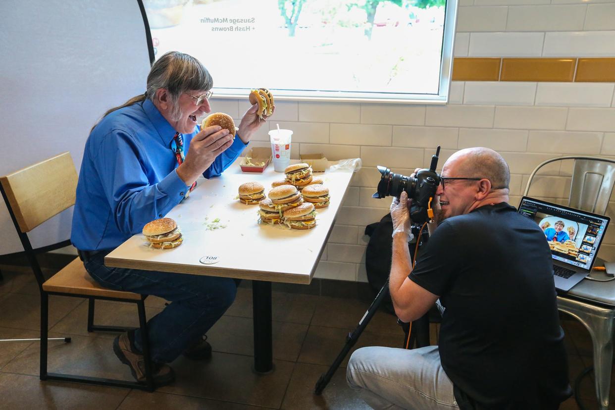 Don Gorske of Fond du Lac poses with a dozen Big Macs July 21, 2021, at the McDonalds on Military Road in Fond du Lac while Guinness World Records photographer Kevin Ramos takes photos.