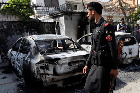 A paramilitary soldier walks past the wreckages of cars after an attack on the Chinese consulate, in Karachi, Pakistan November 23, 2018. REUTERS/Akhtar Soomro