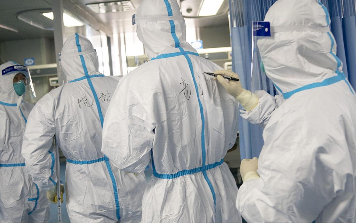 Medical workers write names on each other's protective suits for recognition in Zhongnan Hospital of Wuhan University in Wuhan, central China's Hubei Province - REX