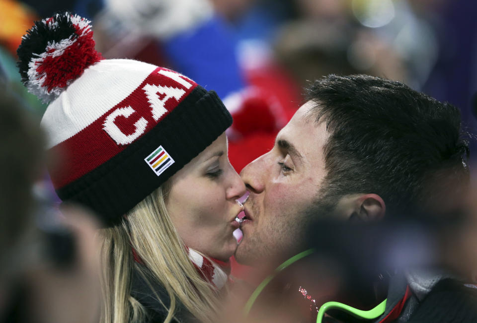 Canada's Alex Bilodeau, right, kisses his girlfriend Sabrina after he won the gold medal in the men's moguls final at the 2014 Winter Olympics, Monday, Feb. 10, 2014, in Krasnaya Polyana, Russia. (AP Photo/Sergei Grits)