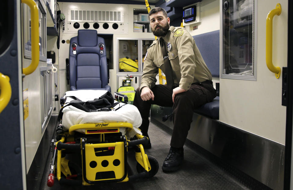 In this Thursday, March 20, 2014 photo, Boston Emergency Medical Services EMT Paul Mitchell sits in an ambulance at his station in the Hyde Park neighborhood of Boston. Mitchell, with bystander Carlos Arredondo and volunteer Devin Wang, are credited with helping to save the life of Jeff Bauman, who suffered traumatic injuries in the Boston Marathon bombings. (AP Photo/Charles Krupa)