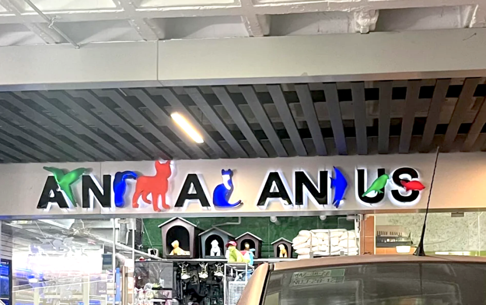 A store sign that says "Animal And Us" but is very hard to ready because half of the letters are replaced with animals