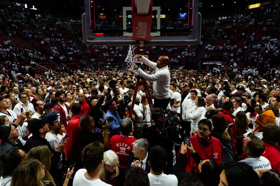 Chris Acker cuts down a net at San Diego State University.