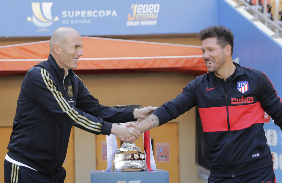 Atletico Madrid's head coach Diego Simone, right, shakes hands with Real Madrid's head coach Zinedine Zidane during the trophy photo call at King Abdullah stadium, in Jiddah, Saudi Arabia, Saturday, Jan. 11, 2020, ahead of their Spanish Super Cup Final soccer match between Real Madrid and Atletico Madrid on Sunday. (AP Photo/Hassan Ammar)