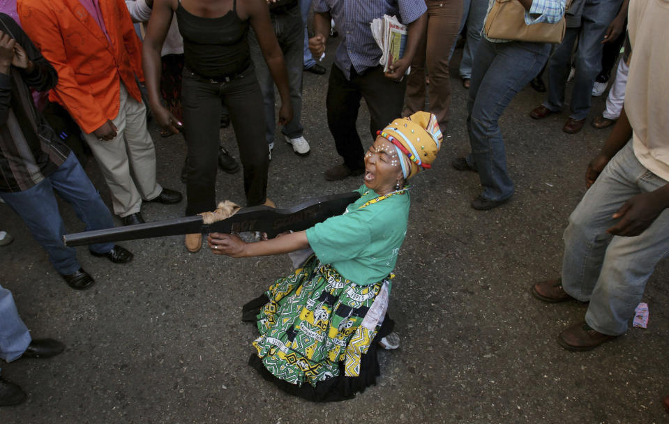 FILE — A woman pretending to fire a mock weapon joins supporters of former deputy president Jacob Zuma in protest outside the High Court in Johannesburg, Wednesday, April 5, 2006 during Zuma's rape trial. For the first time since 1994, the ruling African National Congress (ANC) might receive less than 50% of votes after Zuma stepped down in disgrace in 2018 amid a swirl of corruption allegations and has given his support to the newly-formed UMkhonto WeSiizwe political party. (AP Photo/Denis Farrell/File)