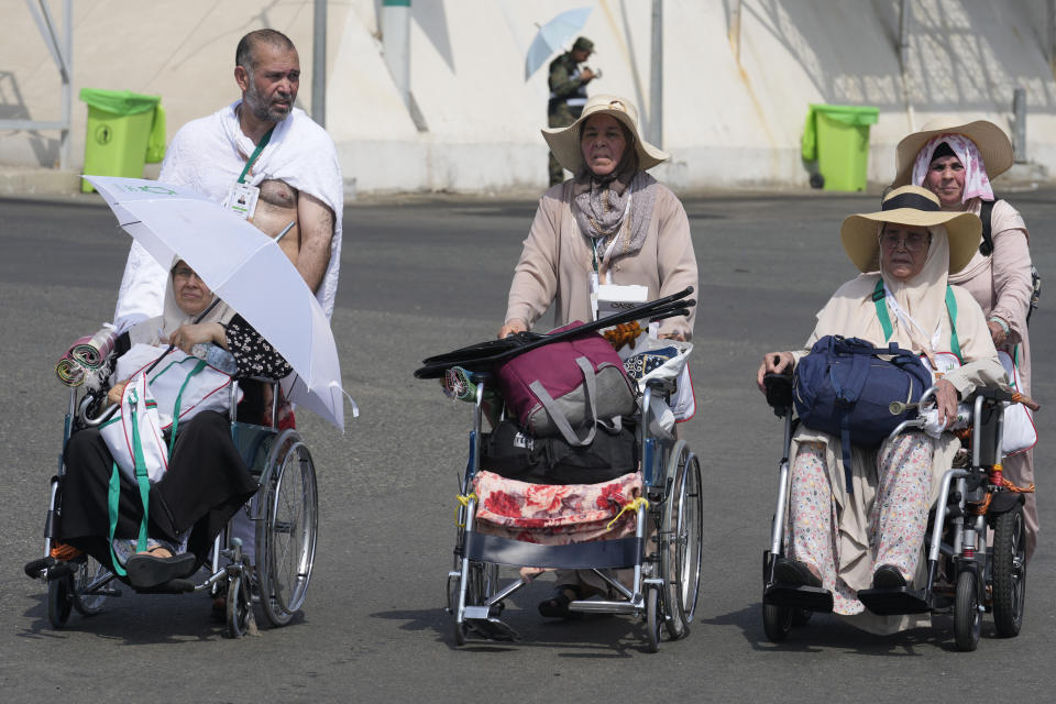 Muslim pilgrims arrive at the Mina tent camp during the annual Hajj pilgrimage, near the holy city of Mecca, Saudi Arabia, Friday, June 14, 2024. Hajj is the annual Islamic pilgrimage to Mecca in Saudi Arabia that is required once in a lifetime of every Muslim who can afford it and is physically able to make it. Some Muslims make the journey more than once. (AP Photo/Rafiq Maqbool)