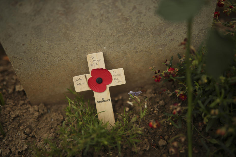 A small wooden cross that reads: "In memory of a fallen soldier no matter the nation" rests at the burial of a German soldier who died during the WWII at the Bayeux War cemetery in Bayeux, Normandy region of France, Wednesday, June 5, 2019. Extensive commemorations are being held in the U.K. and France to honor the nearly 160,000 troops from Britain, the United States, Canada and other nations who landed in Normandy on June 6, 1944 in history's biggest amphibious invasion. (AP Photo/Francisco Seco)