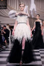 <p>Ein Model trägt bei der Dior Frühjahr/Sommer 18 Haute Couture Modenschau ein schwarz-weißes gefiedertes Kleid mit schwarzem Tüll. (Bild: Getty Images) </p>